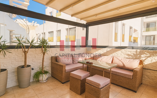 Terrasse couverte aménagée avec salon extérieur en rotin et plantes, appartement à Gauthier Casablanca