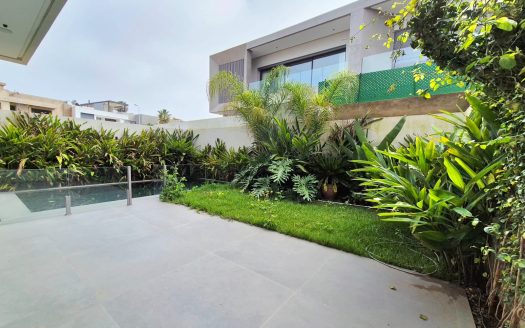Terrasse avec jardin verdoyant et espace extérieur privatif dans villa moderne.